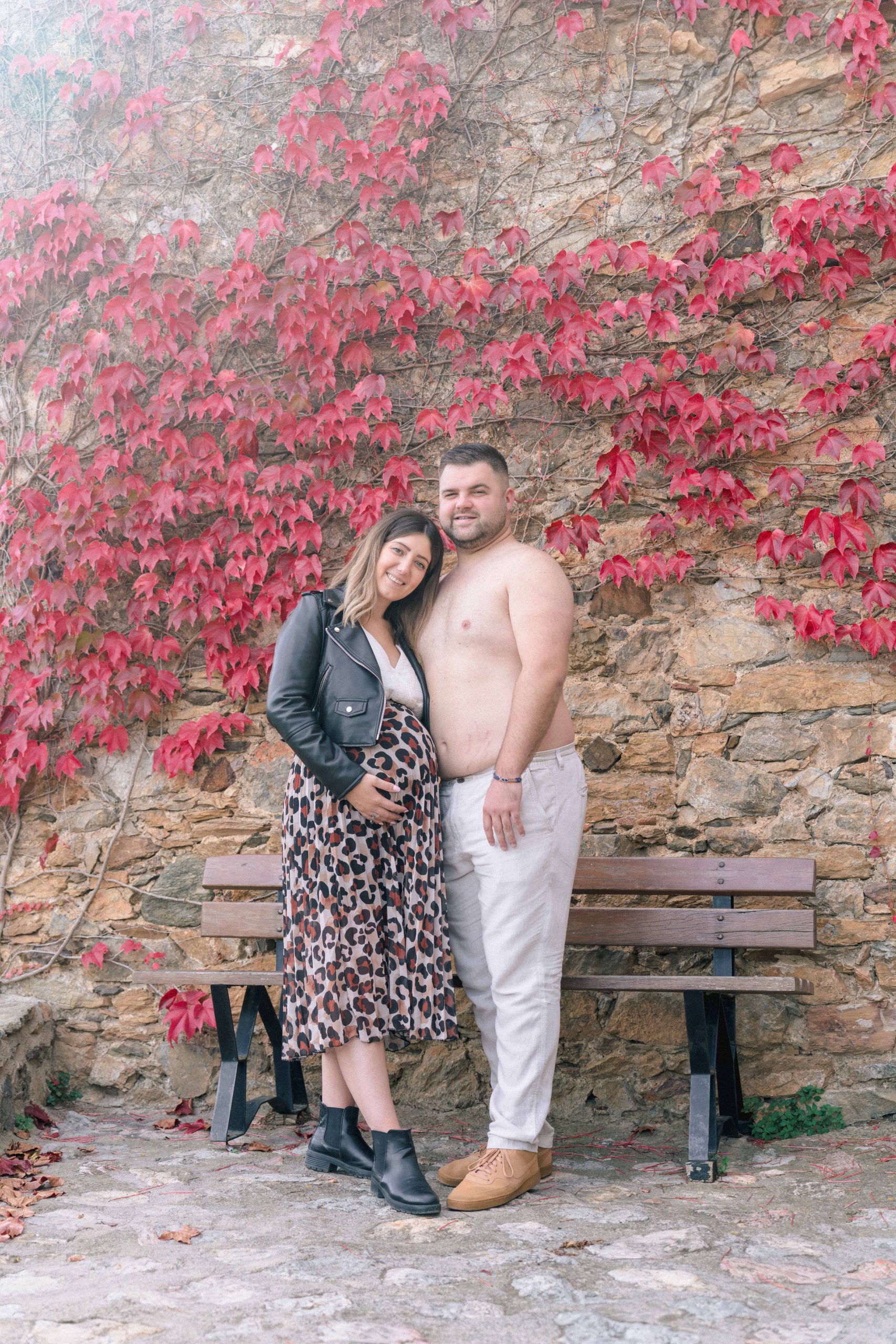Philippe, torse nu, posant tendrement à côté de Marie-Ève, vue de plus loin, lors de leur séance photo de grossesse à Castelnou (66), illustrant la complicité et l'intimité du couple dans un cadre plus large.